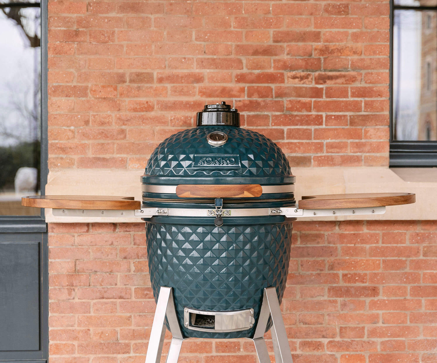 Kamado Kokko nouvelle édition présenté sur son chariot, mettant en valeur le design, la céramique texturée et l’intégration dans un espace extérieur.
