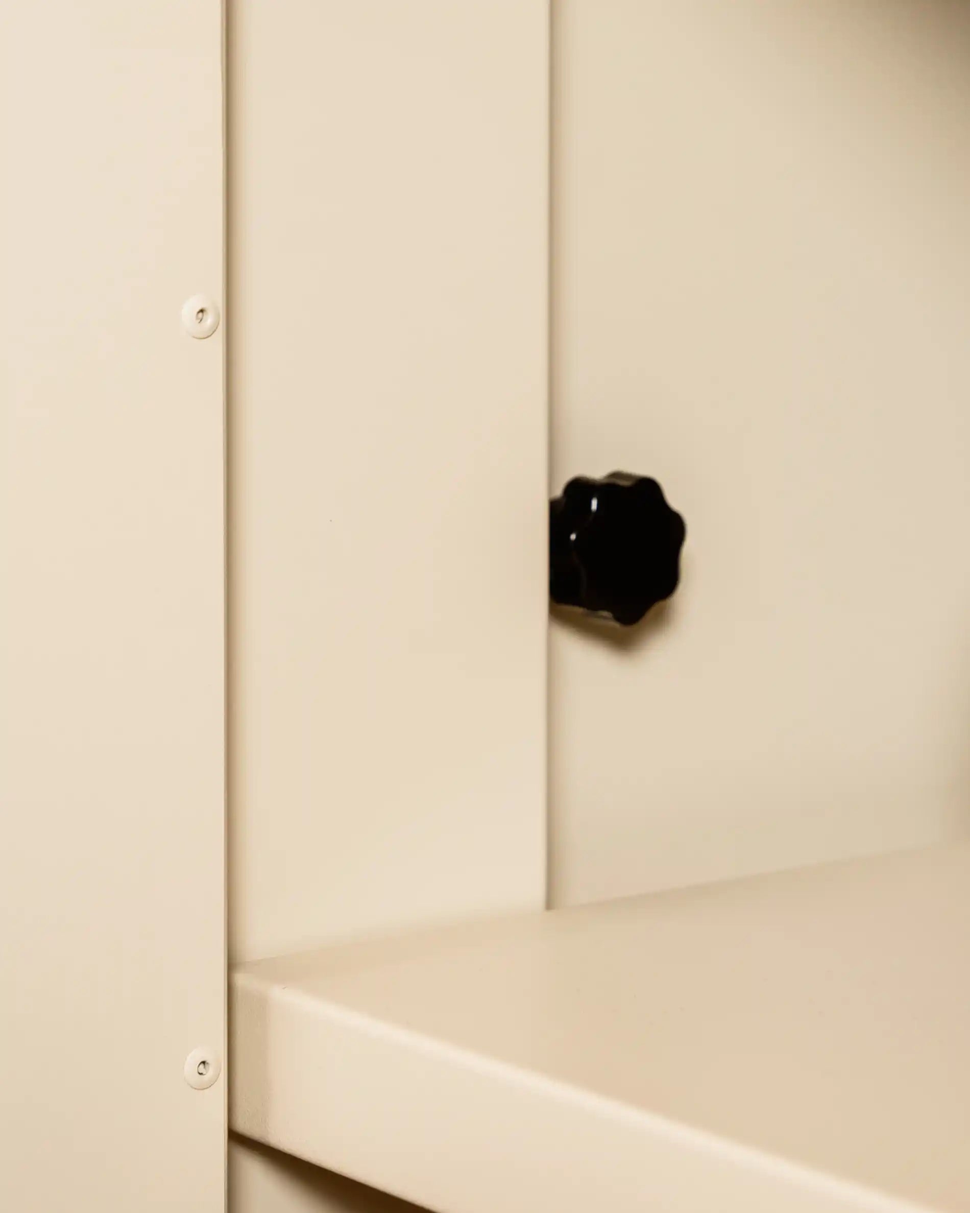 Rueda de ajuste beige crema PILOTIS instalada en el ángulo del mueble