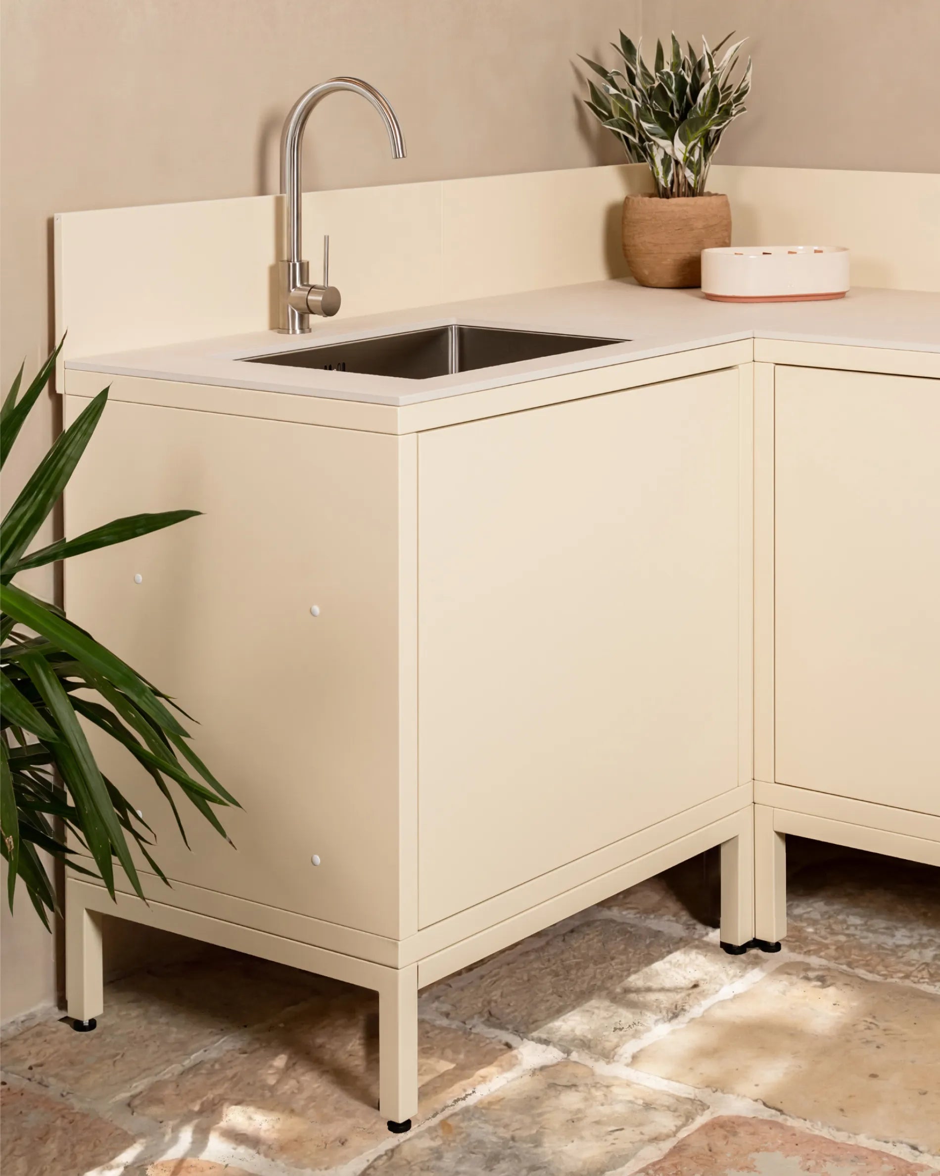 Estructura baja beige crema PILOTIS bajo módulo de esquina para fregadero, cocina exterior con grifo y planta
