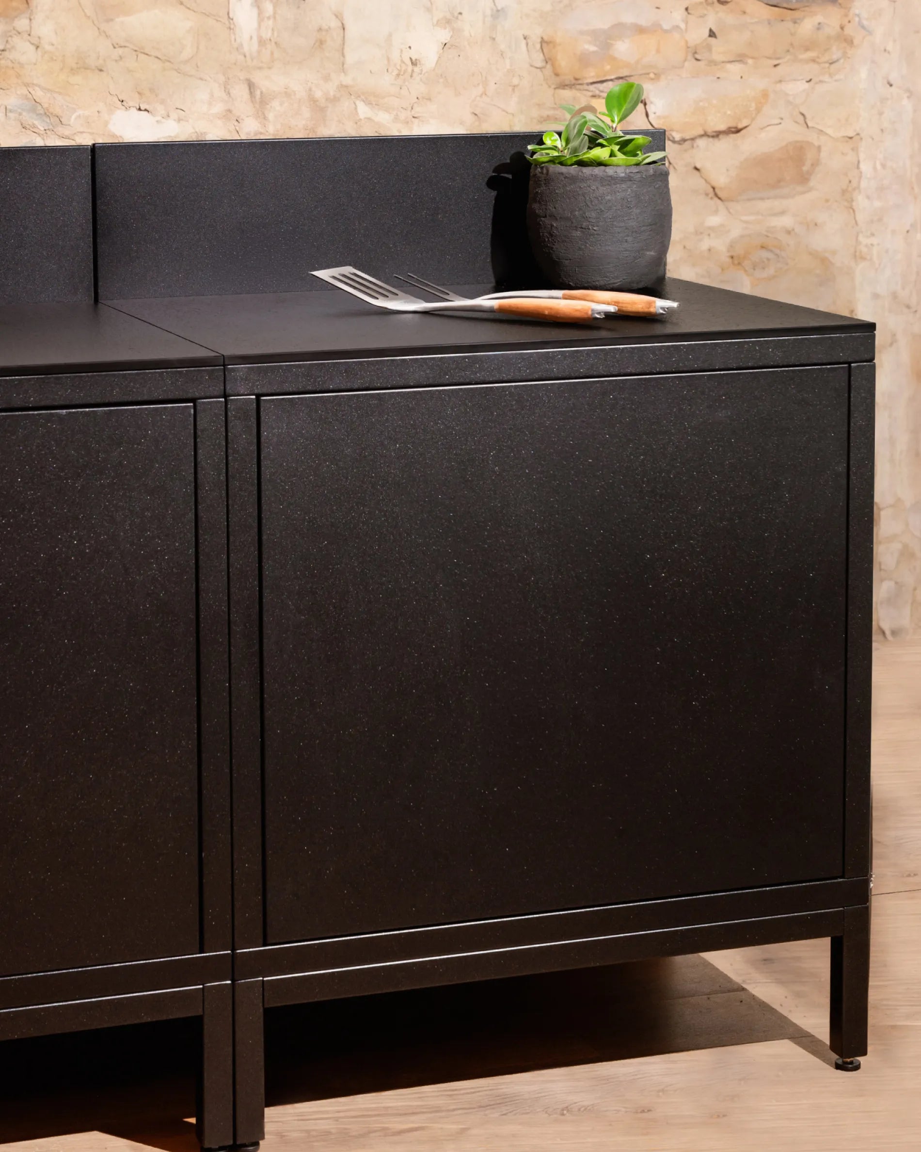 Módulo Classic PILOTIS en negro para cocina exterior, con encimera, planta decorativa y cubiertos