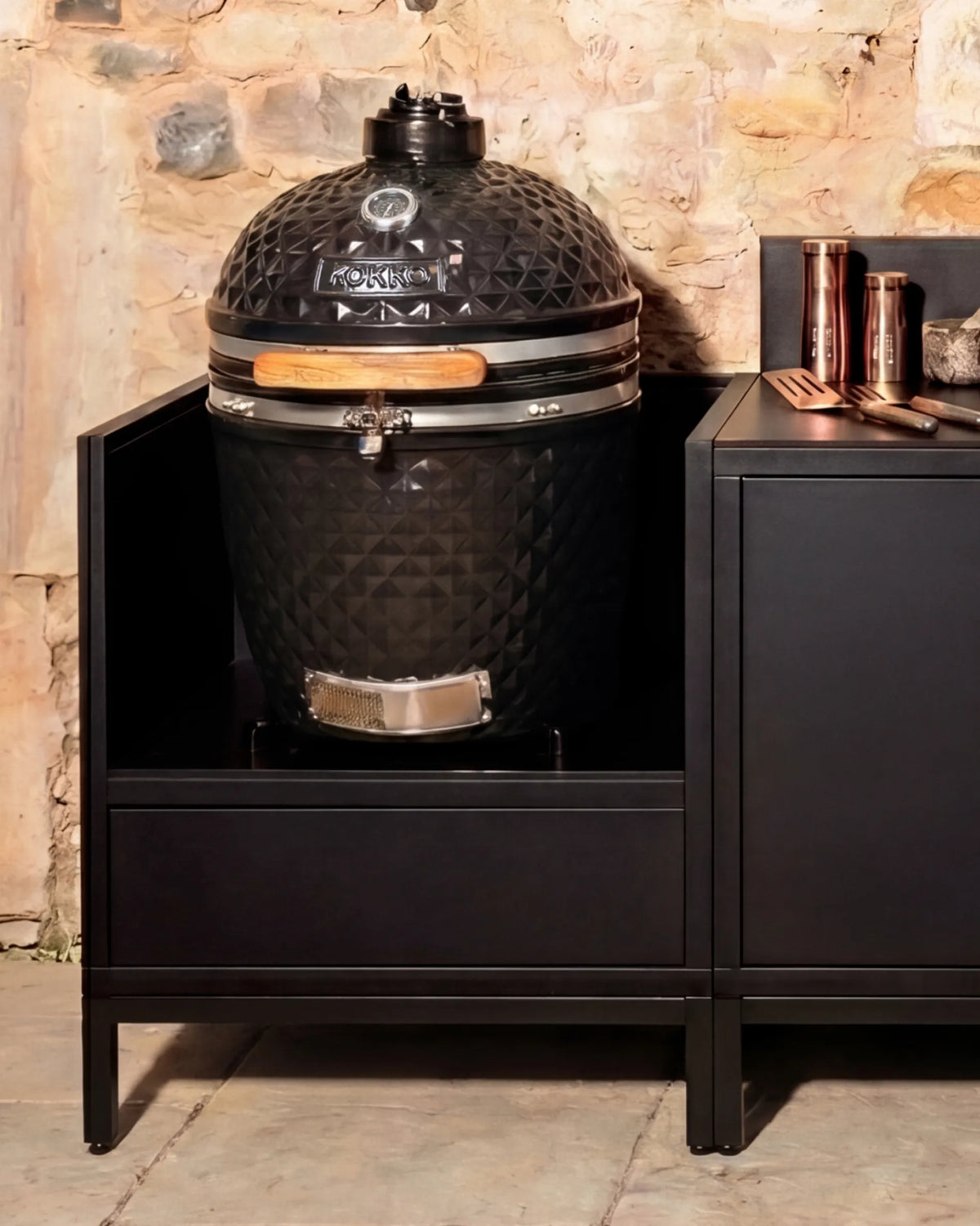 Kamado en cerámica negro Kokko instalado en módulo PILOTIS con accesorios de cobre, cocina exterior