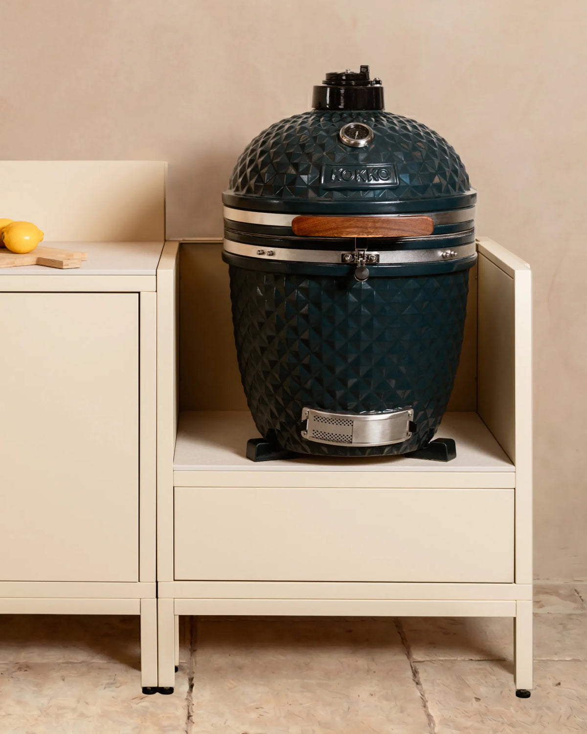 Kamado en cerámica azul marino Kokko instalado en módulo beige crema PILOTIS, cocina exterior