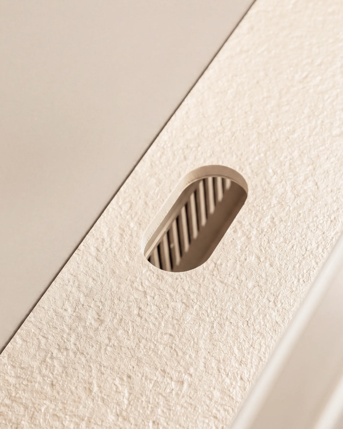 Corte ovalado del tablero beige crema del módulo Plancha PILOTIS, primer plano de la textura granitada