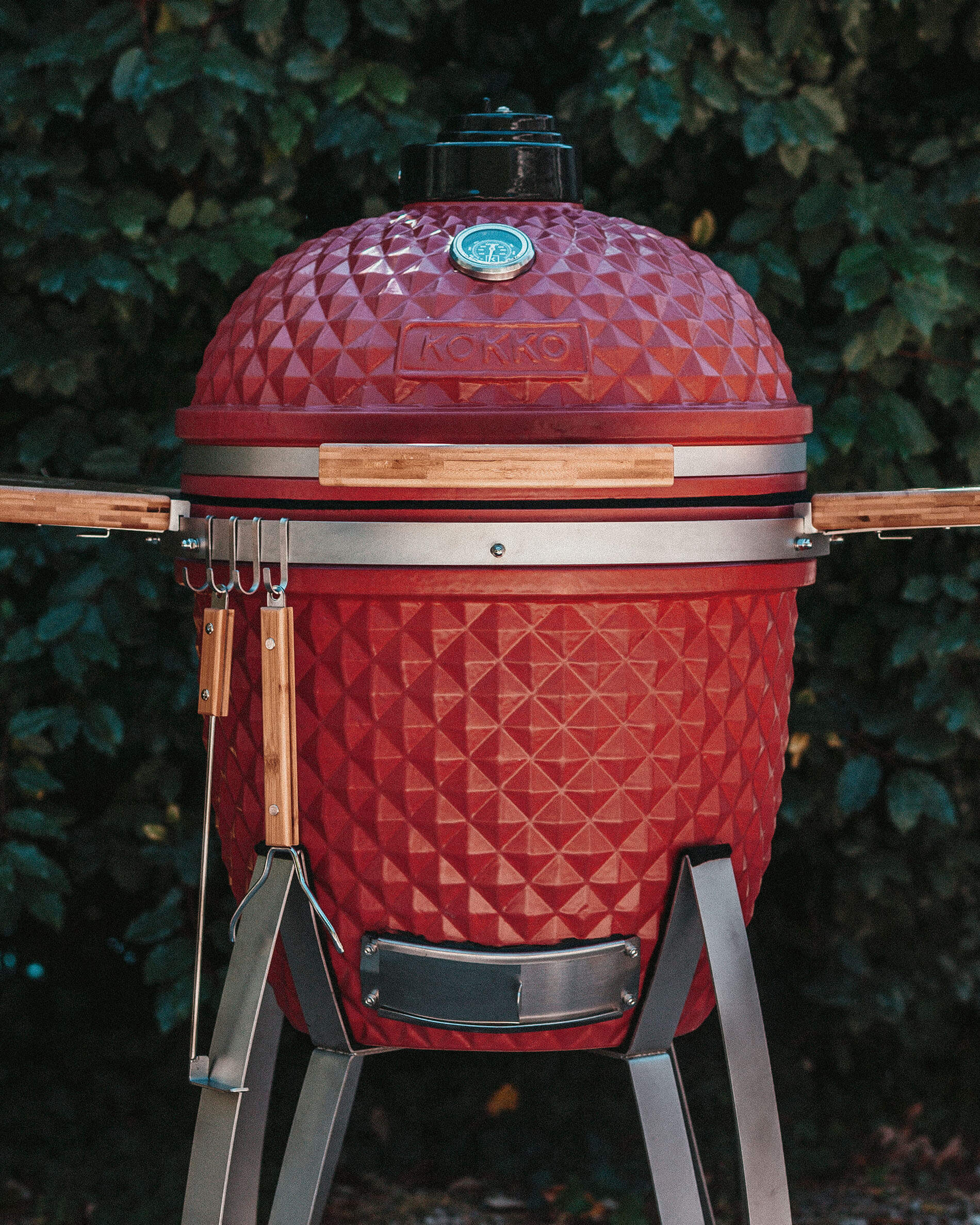 Kamado Kokko rojo equipado con ganchos para accesorios.