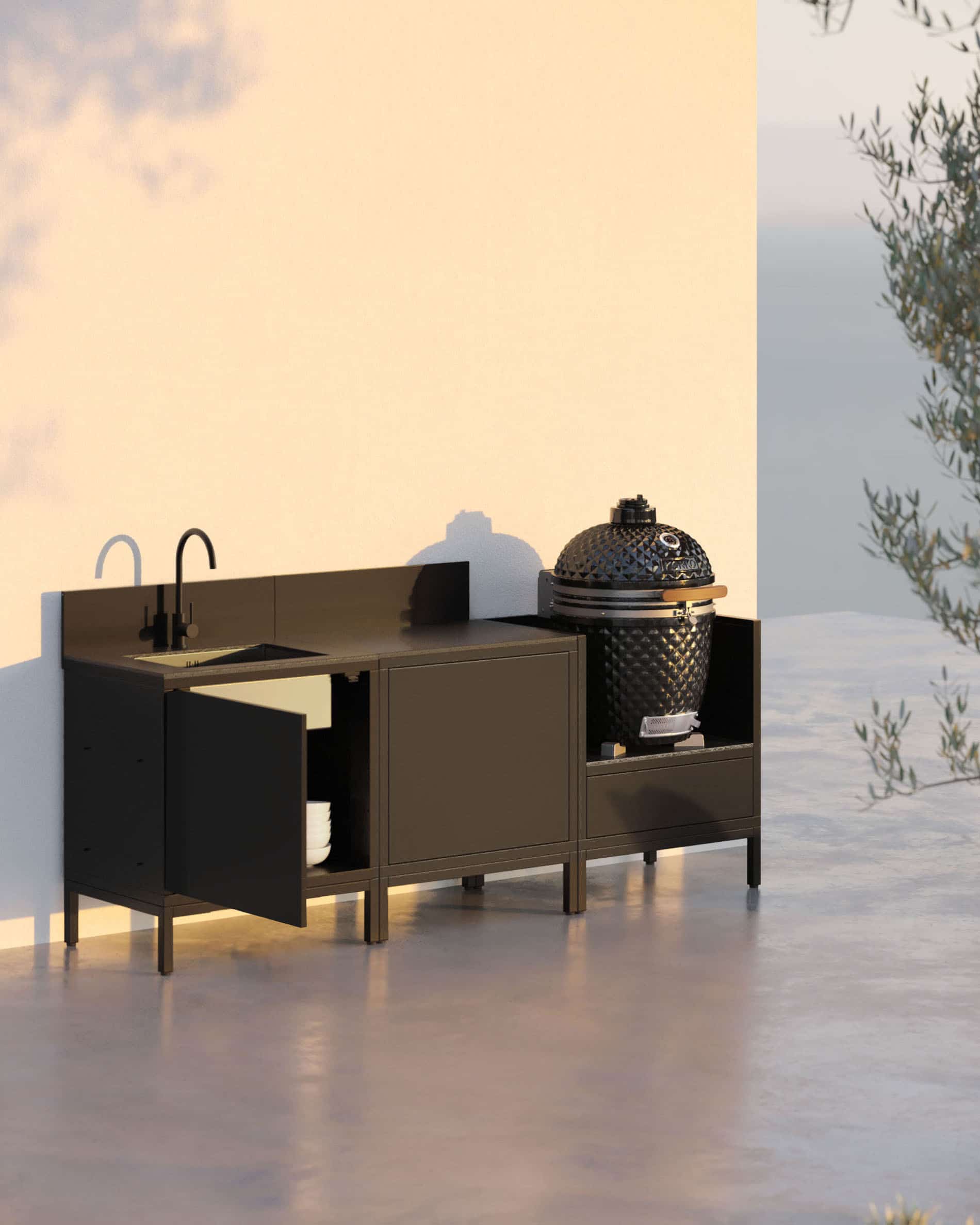 Cocina exterior pilotis de 3 módulos para kamado con fregadero integrado, mueble en color negro con encimera y salpicadero a juego, fregadero con grifo a la izquierda, módulo central de almacenamiento cerrado y kamado integrado en el módulo lateral derecho, estructura sobre patas negras, instalación para exteriores.
