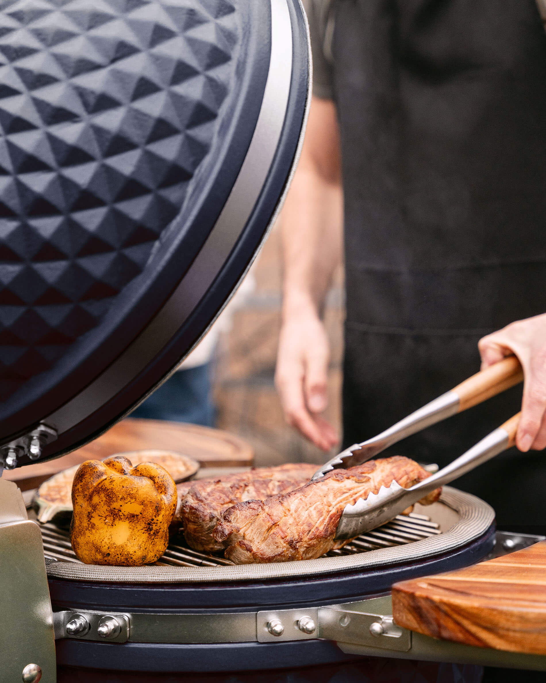 Kamado Kokko L 18 pulgadas azul marino en acción durante una parrillada.