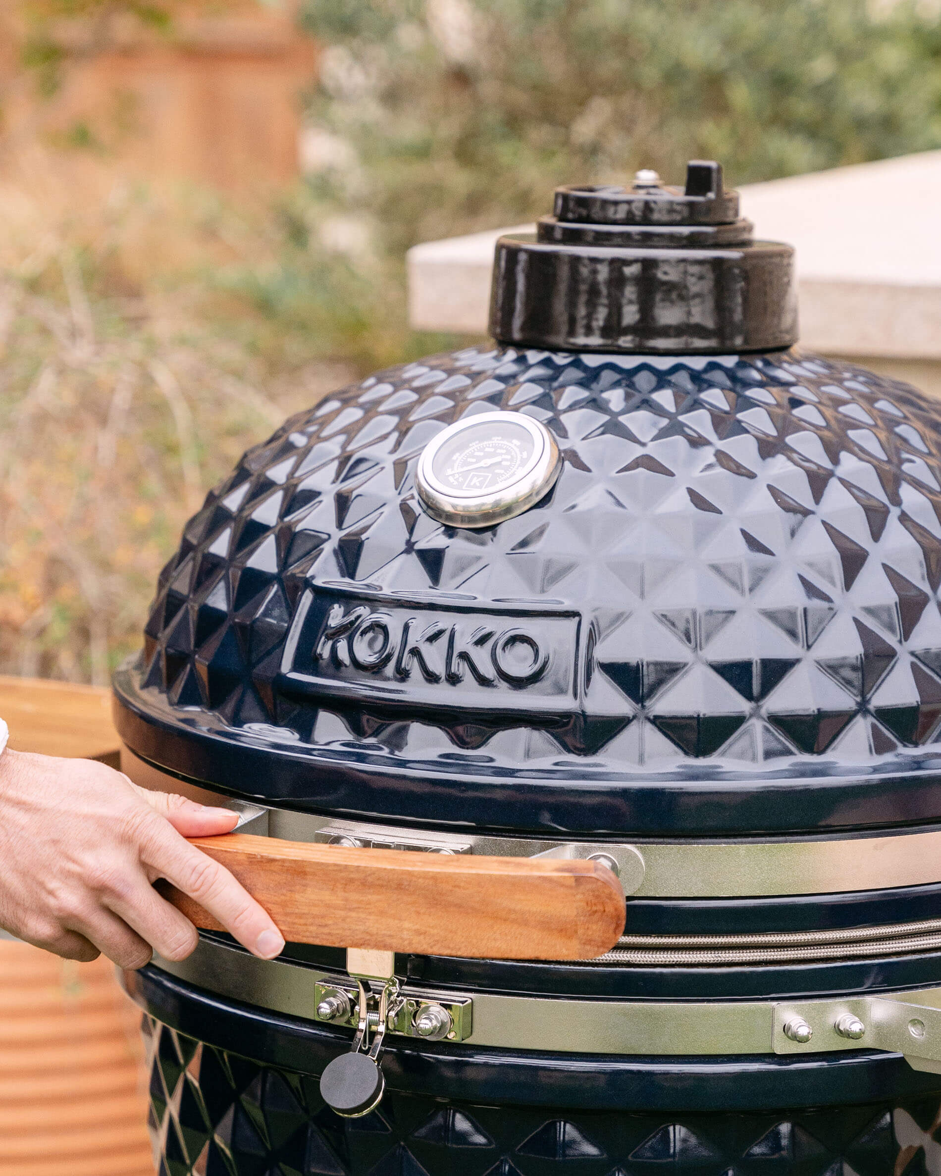 Primer plano de la tapa de un kamado Kokko XL de 22 pulgadas en cerámica azul marino.