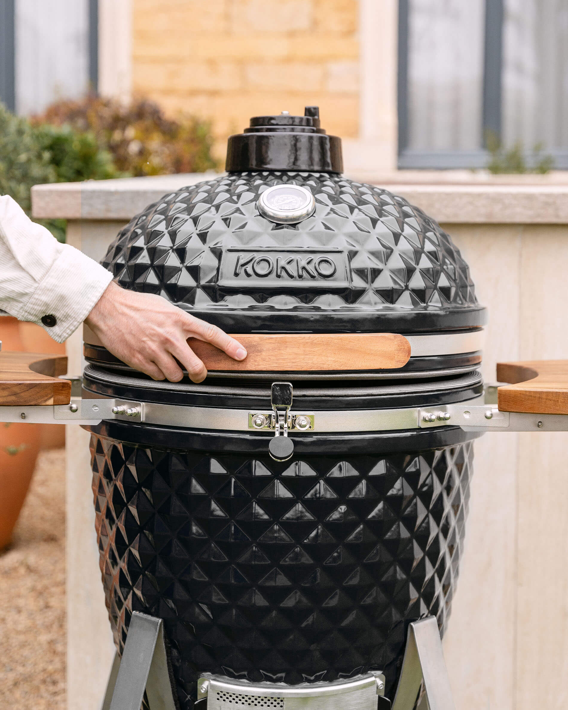 Kamado Kokko XL de 22 pulgadas en cerámica negra instalado en exterior.