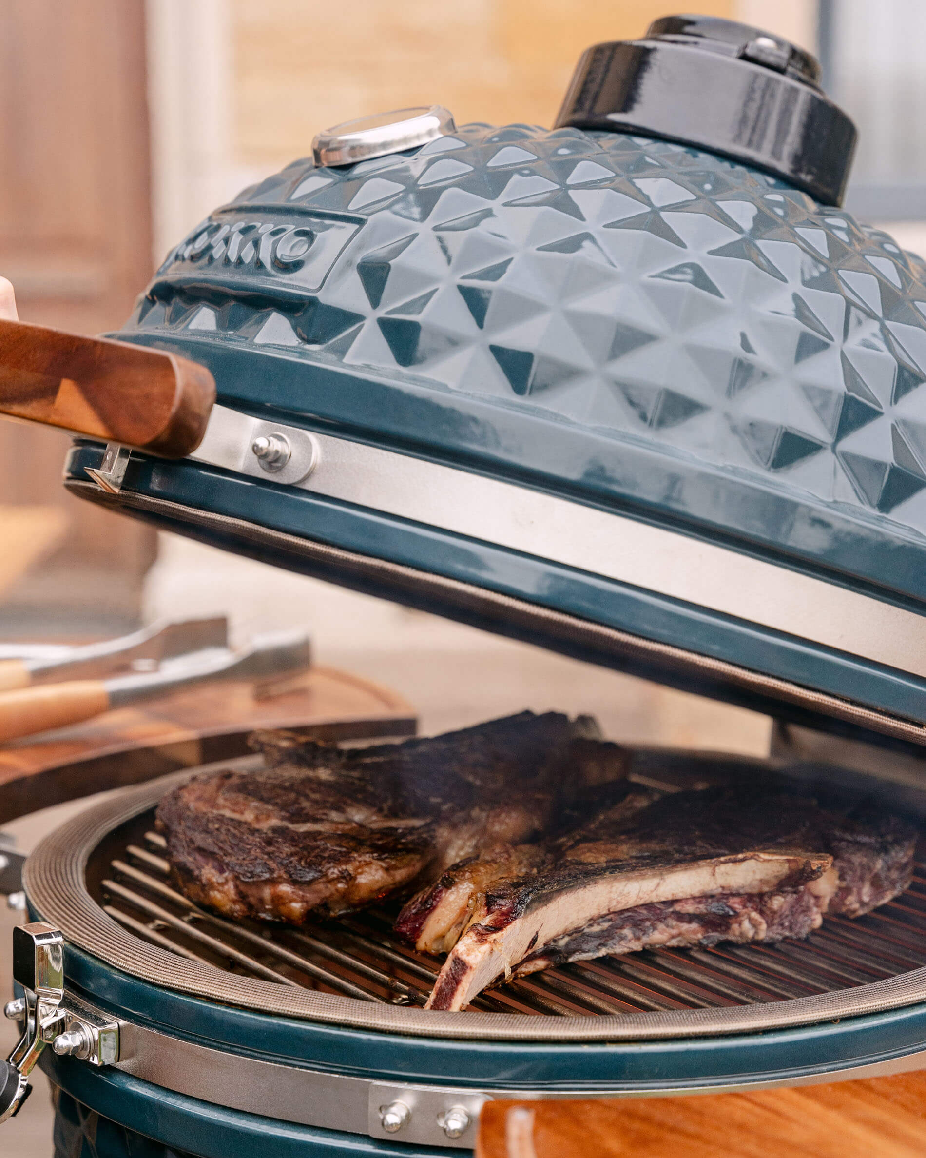 Detalle de la tapa de un kamado Kokko XL de 22 pulgadas en cerámica azul océano.