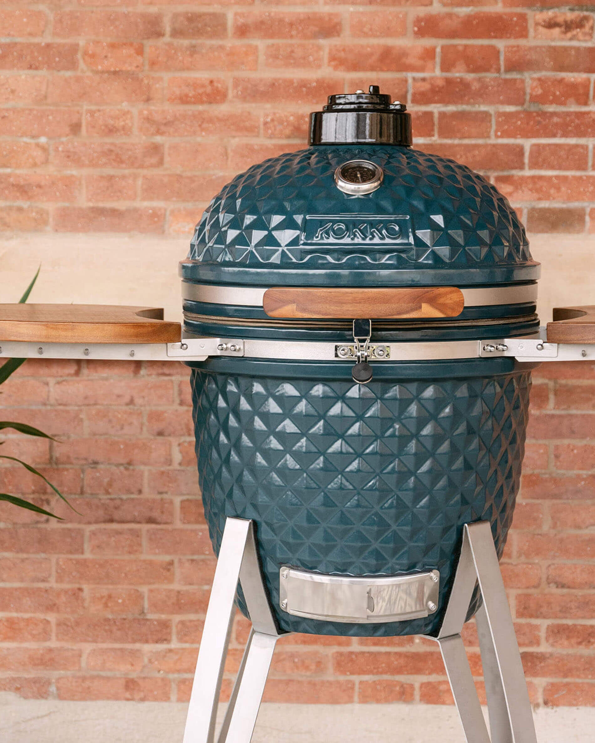 Kamado Kokko de 22 pulgadas en color océano, presentado solo en exterior.