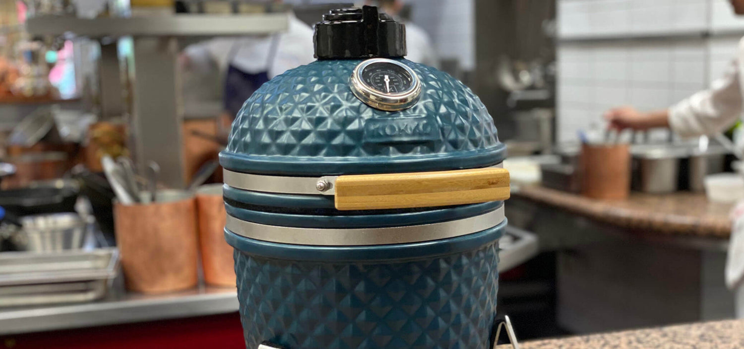 Kamado Kokko azul océano instalado frente a un restaurante gastronómico Paul Bocuse.