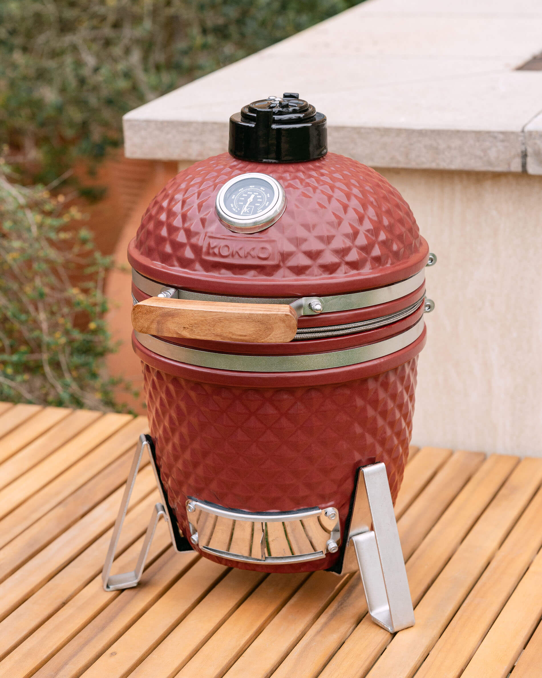 Kamado Little Kokko 13 rojo óxido instalado en una terraza.