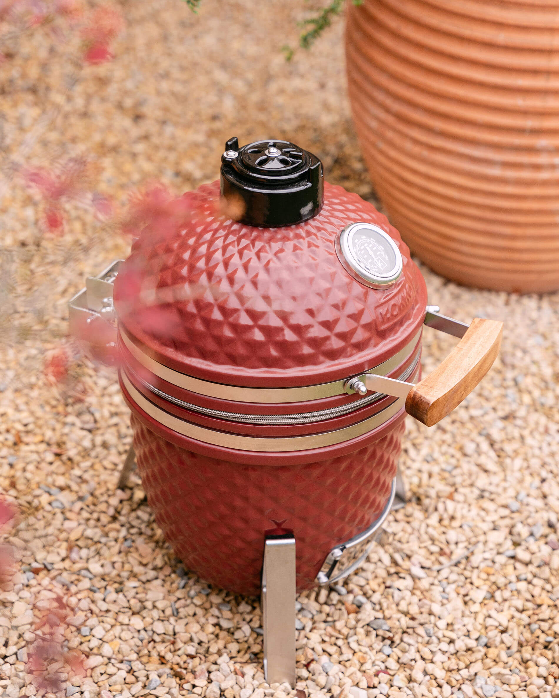 Kamado Little Kokko 13 de cerámica en rojo óxido visto de frente.