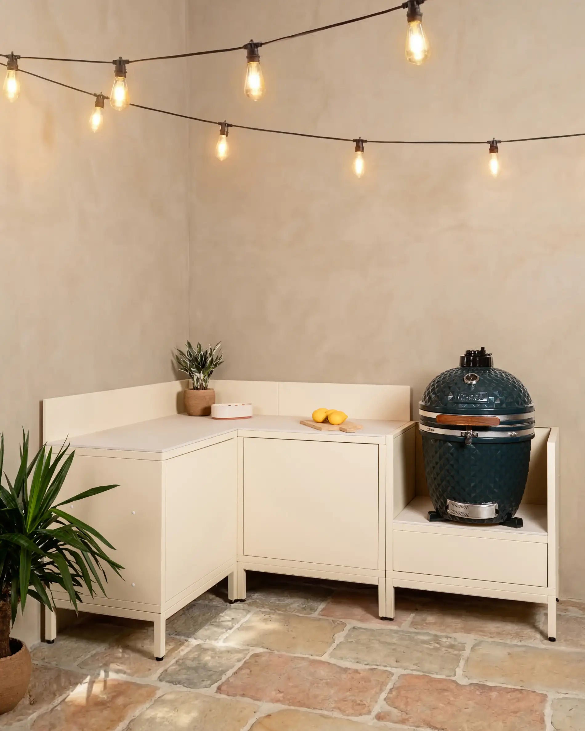 Cocina exterior Kokko crema en esquina con kamado y encimera