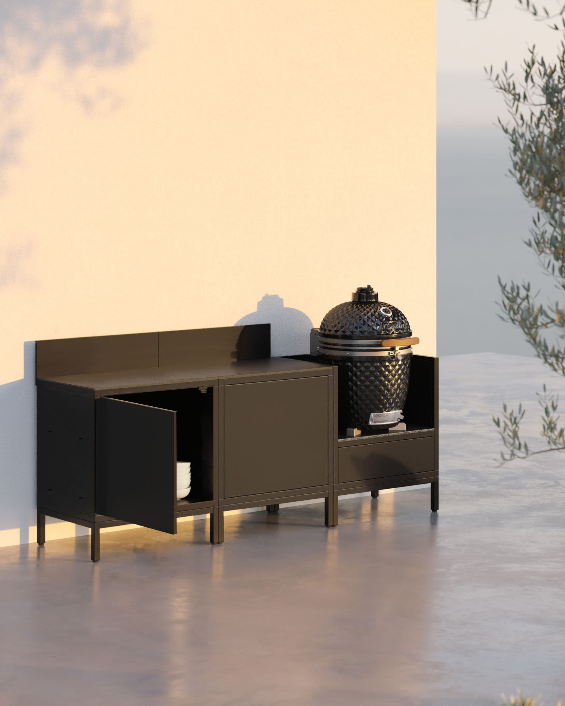 Cocina sobre pilotis de 3 módulos con kamado, mueble negro y una puerta de almacenamiento abierta.