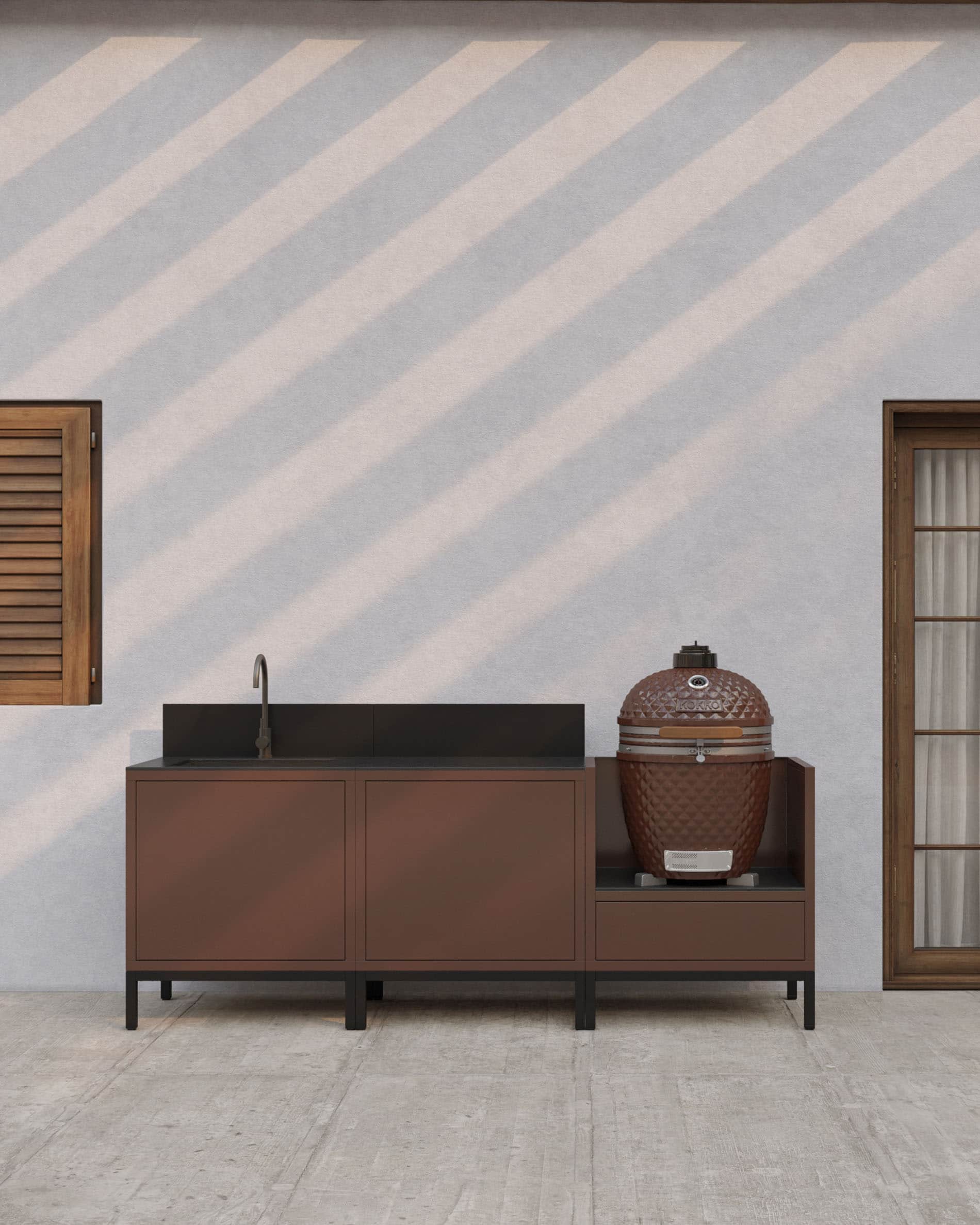 Cocina sobre pilotes en acabado óxido con fregadero integrado, encimera oscura, salpicadero a juego y módulo kamado dedicado sobre estructura elevada.