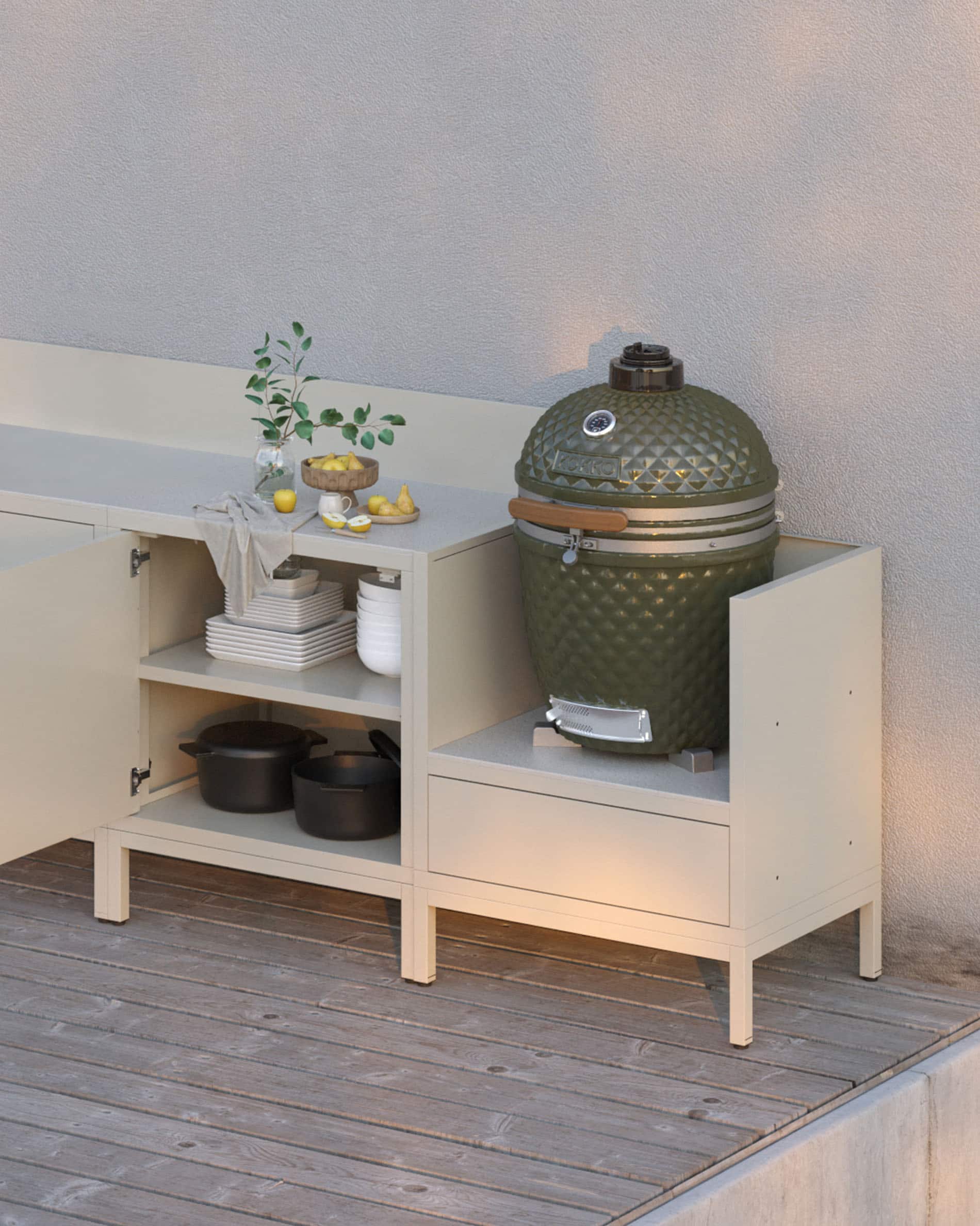 Cocina modular sobre pilotis en color crema, con encimera clara, estantes abiertos y módulo dedicado para integrar un kamado.