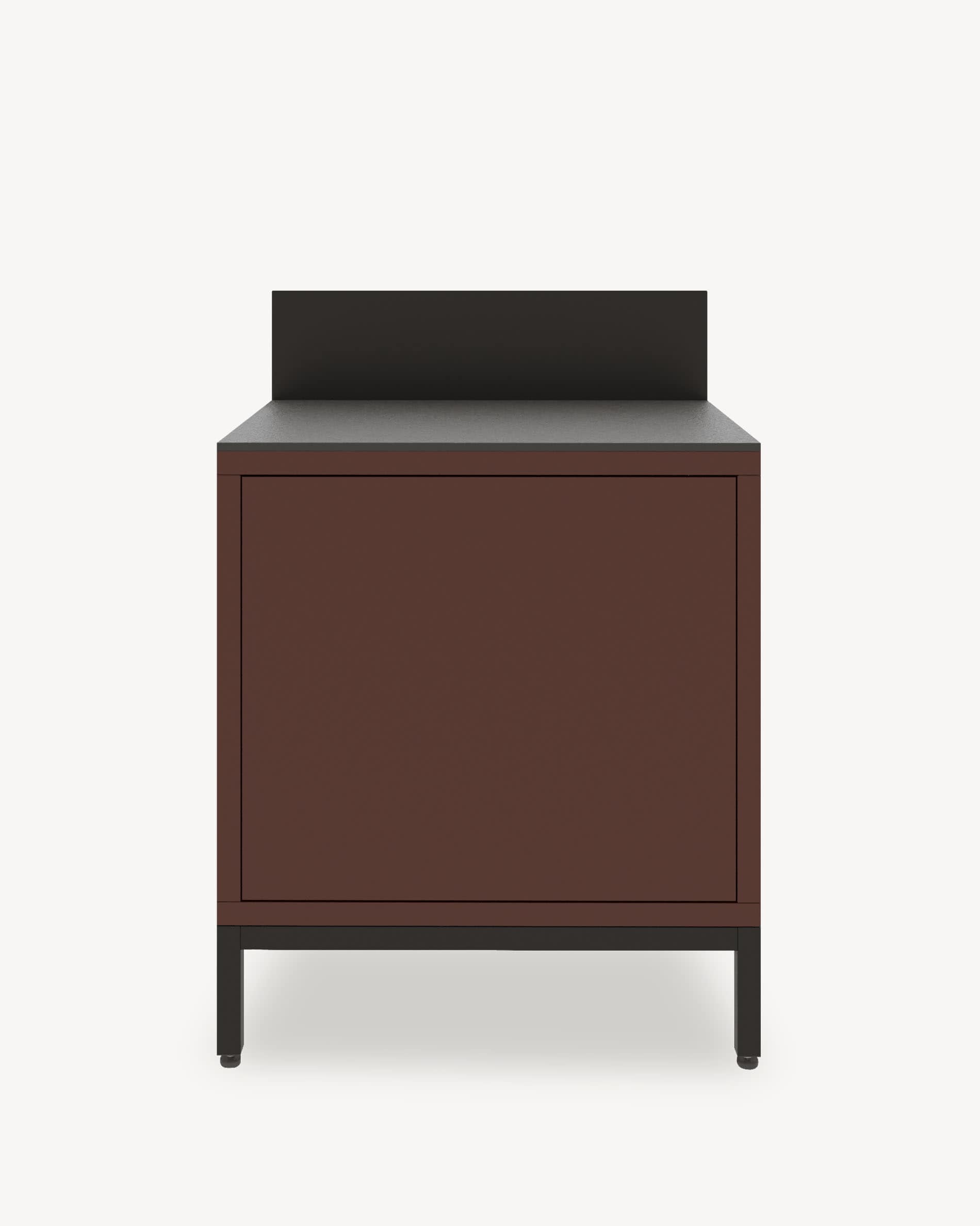 Módulo de cocina pilotis con almacenamiento cerrado, frente en color marrón óxido, encimera oscura y panel protector integrado.