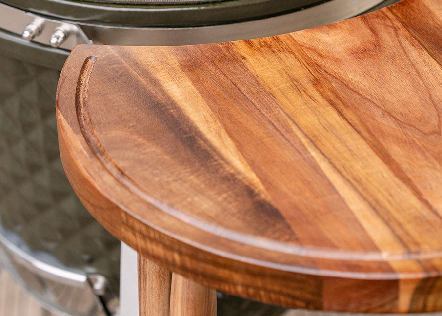 Plateau latéral en bois d’acacia du kamado Kokko, fixé sur la structure métallique pour servir de surface de préparation.